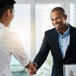 Shot of two young businessmen shaking hands in a modern office